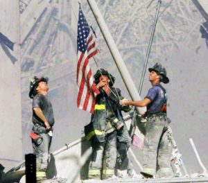 Firefighters raise a flag late in the afternoon on Tuesday, Sept. 11, 2001, in the wreckage of the World Trade Center towers in New York. In the most devastating terrorist onslaught ever waged against the United States, knife-wielding hijackers crashed two airliners into the World Trade Center on Tuesday, toppling its twin 110-story towers. (AP Photo/The Record, Thomas E. Franklin) MANDATORY CREDIT