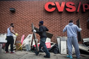 BALTIMORE, MD - APRIL 28: Volunteers help clean up debris from a CVS pharmacy that was set on fire yesterday during rioting after the funeral of Freddie Gray, on April 28, 2015, in Baltimore, Maryland. Gray, 25, was arrested for possessing a switch blade knife April 12 outside the Gilmor Houses housing project on Baltimore's west side. According to his attorney, Gray died a week later in the hospital from a severe spinal cord injury he received while in police custody. (Photo by Andrew Burton/Getty Images)