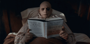 Uncle Fester reading a self-help book while lying in bed
